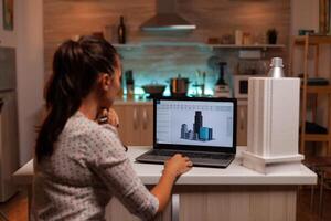 Architect holding building model while working on a project during night in home. Engineer artist creating and working in office holding scale building model, determination, career. photo