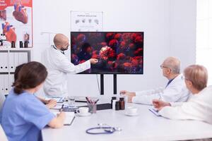 Medical specialist talking about coronavirus during presentation in front of expert doctos. Specialist doctor discussing with colleagues about global pandemic because of dangerous virus, symptoms. photo