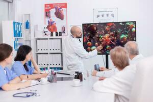 Doctor holding presentation about coroanvirus symptoms in front omf medical team. Specialist doctor discussing with colleagues about global pandemic because of dangerous virus, photo