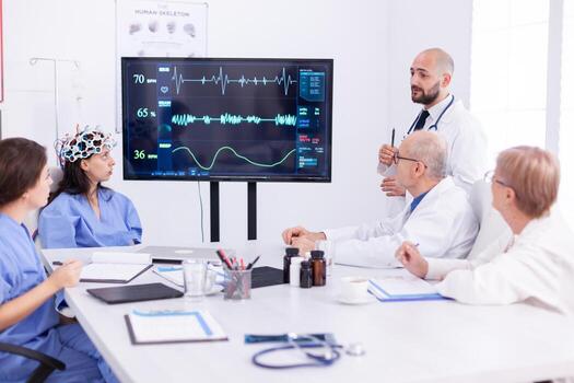 Nurse wearing scanner for brain waves during medical experiment for neuoroscience conference. Monitor shows modern brain study while team of scientist adjusts the device. photo