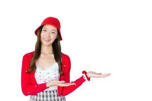 Beautiful young Asian woman who wears red coat and red cloth hat as santy girl acts her hand to present something on the white background. photo