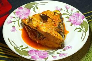 Fish head cooked with spices on a plate photo