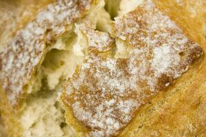 Close up of broken freshly baked bread. Texture of wheat bread. photo