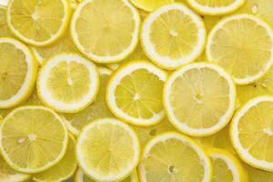 Bright lemon background. Lemon slices full frame. photo