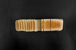 rebanado trigo brindis un pan en un negro antecedentes. despellejar poner. foto