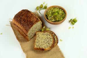 Organic bread of whole grain flour and hop sourdough. Dry hop flowers in wooden bowl and homemade bread. Craft bakery concept photo