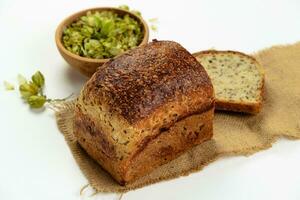 Organic bread of whole grain flour and hop sourdough. Dry hop flowers in wooden bowl and homemade bread. Craft bakery concept photo