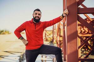 adulto hombre es Listo para hacer ejercicio al aire libre en soleado día. foto