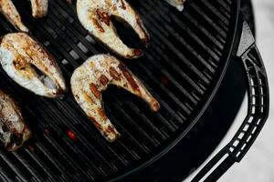 hombre interrogatorio intenso delicioso pescado en un portátil barbacoa, Nevado invierno parilla foto