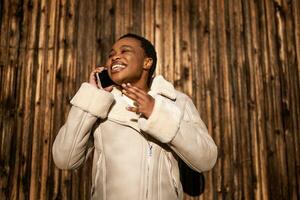 Outdoor portrait of african-american woman. She is talking on phone. photo