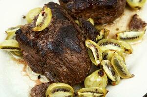 Grilled ostrich steak with kiwi berries photo