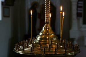 Iglesia velas quemar en un candelero en contra el fondo de íconos foto