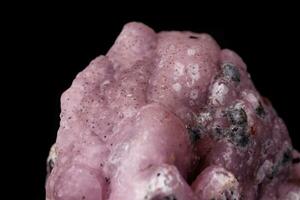 Macro pink Smithsonite mineral stone on microcline on black background photo