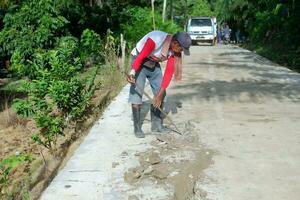 Kuaro Kalimantan Timur, Indonesia 11 November 2023. The village community was seen working together to repair the damaged road photo