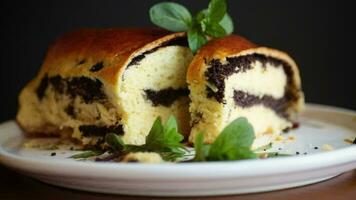 roll with poppy seeds inside on a wooden table. video