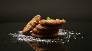 cooked sweet oatmeal cookies on black background video