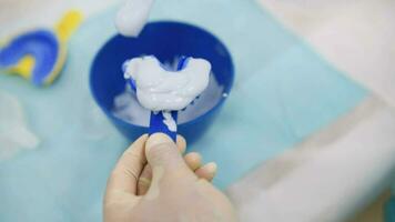 une médecin fait du une modèle de une Humain mâchoire en dehors de plâtre dans un orthodontique clinique. contrôle et diagnostique jette pour aligneurs. video