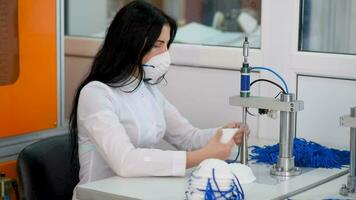 Girls work at the machine for the manufacture of medical masks with nanofibre and solder the loops to them with ultrasound. Coronovirus and Covid-19 Prevention video