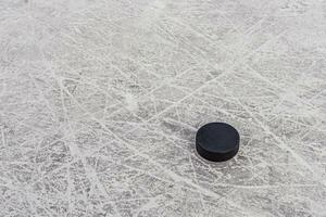 hockey puck lies on the snow macro photo