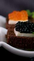 particionado plato con negro y rojo caviar en de madera antecedentes video