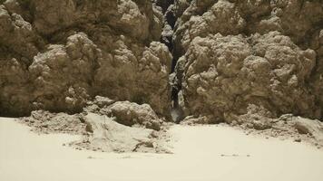 A group of rocks sitting on top of a sandy beach video