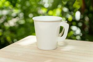 a white paper coffee cup in the morning time photo