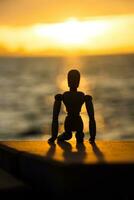 Silhouettes of wooden models feel lonely at sunset. photo