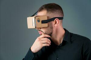 Man using a new virtual reality headset on grey background photo