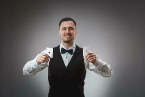 Young man in shirt and waistcoat shows his poker cards, studio shot photo