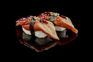 Two nigiri sushi with eel, unagi sauce and sesame photo