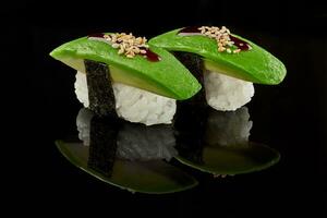 Two nigirizushi with avocado, unagi sauce and sesame photo