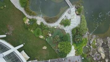 Top view of adjacent territory of country mansion with patio and artificial pond in summer day photo