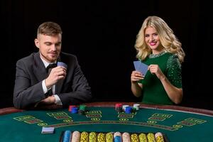 View of young, confident, man with the lady while he's playing poker game. Man bets in poker photo