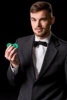 man in a suit posing with chips for gambling photo