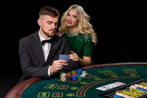 View of young, confident, man with the lady while he's playing poker game. photo