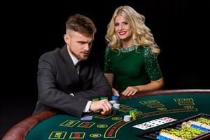 View of young, confident, man with the lady while he's playing poker game. photo