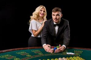 View of young, confident, man with the lady while he's playing poker game. photo