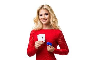 Caucasian young woman with long light blonde hair in evening outfit holding playing cards and chips. Isolated. Poker photo