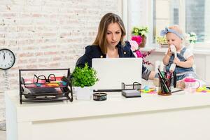 Businesswoman mother woman with a daughter working at the computer photo