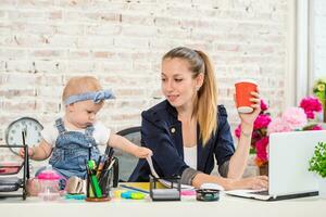 Businesswoman mother woman with a daughter working at the laptop photo