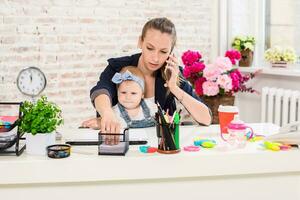 Family Business - telecommute Businesswoman and mother with kid is making a phone call photo