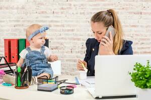 Family Business - telecommute Businesswoman and mother with kid is making a phone call photo