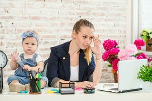 Businesswoman mother woman with a daughter working at the laptop photo