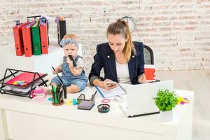 Businesswoman mother woman with a daughter working at the laptop photo