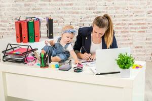 Businesswoman mother woman with a daughter working at the laptop photo