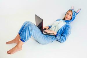 niña en pijama con un ordenador portátil acostado en el piso foto