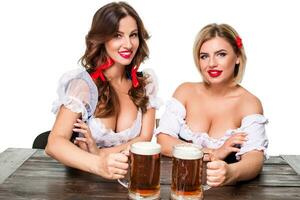 Two beautiful blond and brunette girls of oktoberfest beer stein photo