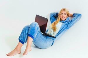 girl in pajamas with a laptop lying on the floor photo