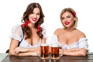dos hermosa rubio y morena muchachas de Oktoberfest cerveza Stein foto