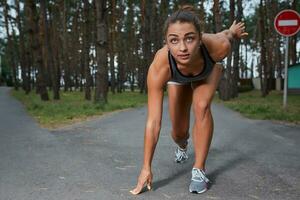 Young woman running outdoors in a city park photo